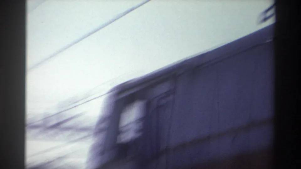 Motion-blurred passenger carriage speeding past the camera on what appears to be the Taiwan Railway, circa 1982, overhead catenary wire visible.