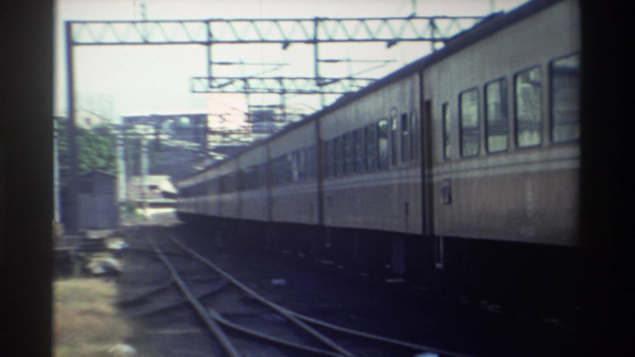 1982 Taiwan 8mm frame showing passenger carriages moving through multiple rails beneath overhead electrical gantries.