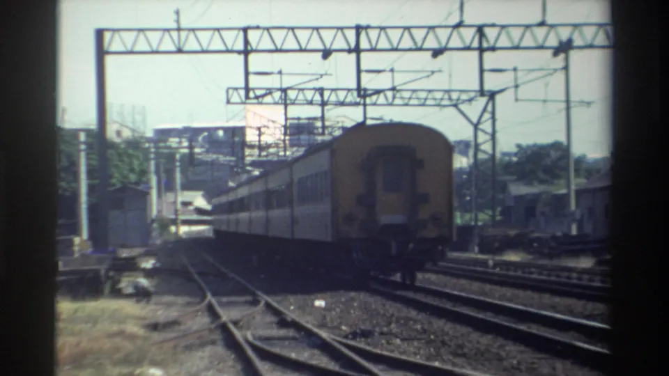 1982 Taiwan 8mm frame showing the receding rear car centered among rails and overhead electric supports.