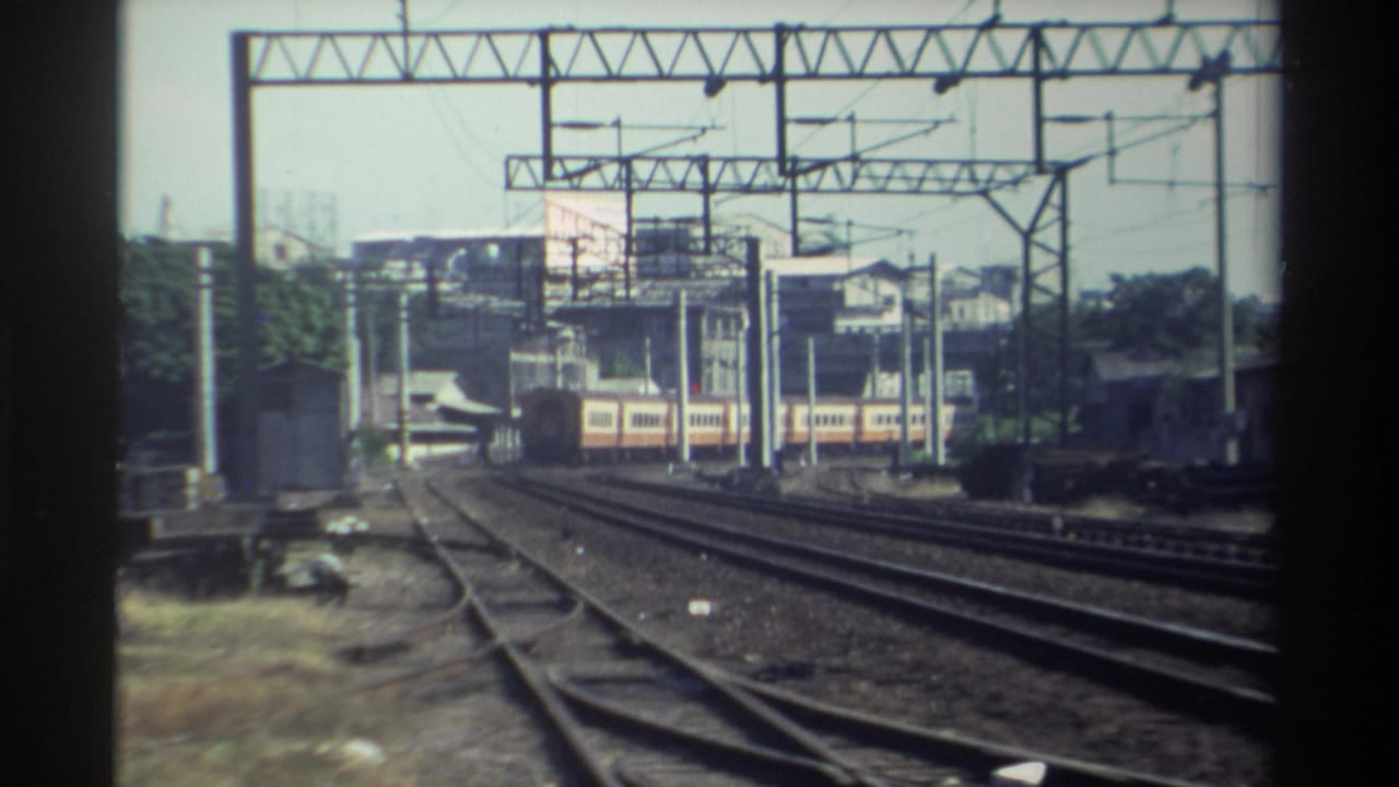 Cream-and-red passenger train continues through a Taiwan rail corridor, framed by catenary structures and soft 8mm edges.