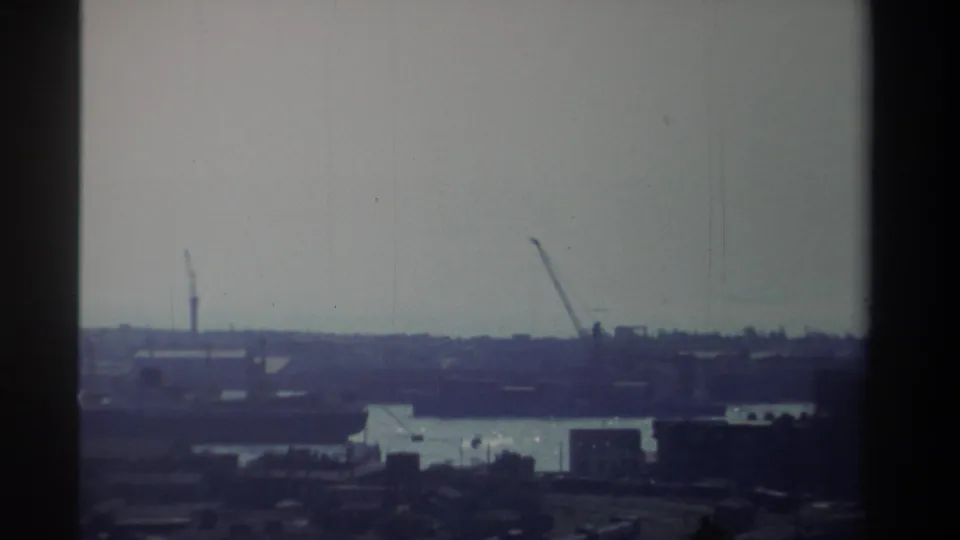 1982 Taiwan frame showing a port or industrial waterfront with cranes and low dockside structures across the water.