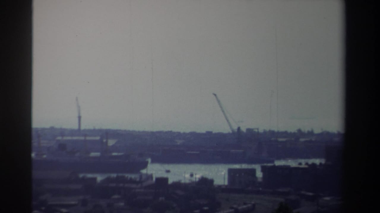 1982 Taiwan port view with cranes and waterfront structures seen through grainy, faded 8mm home-movie footage.