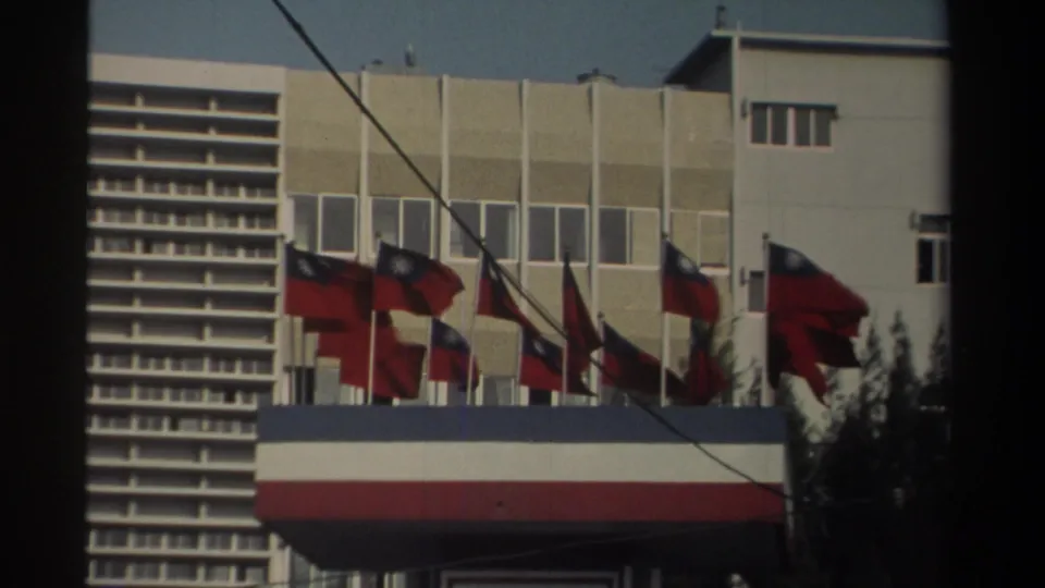 1982 Taiwan exterior showing multiple Republic of China flags flying in front of a modern building and striped awning.