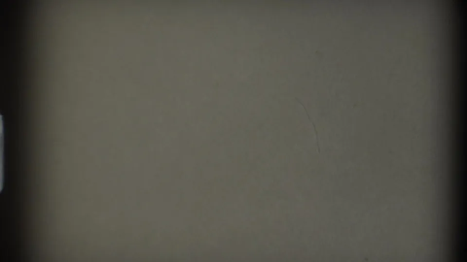 End-of-roll style blank 8mm frame with muted green-gray exposure, soft vignetting, and faint film marks.