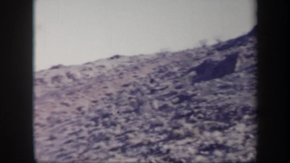 Rocky Arizona hillside in a faded 8mm home-movie frame, with no clearly visible people in this still.