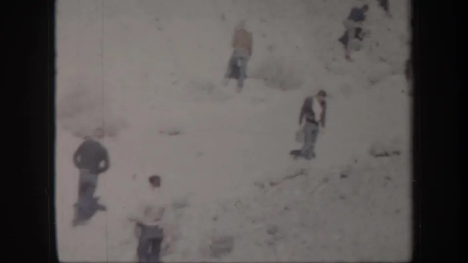 Several men in mid-century outdoor clothing appear on a bright Arizona desert slope in soft 8mm footage.