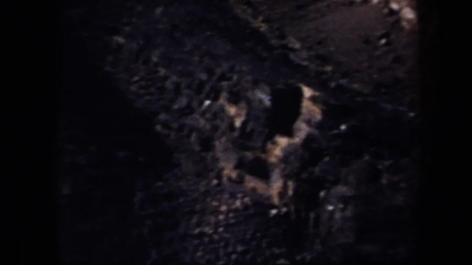 The final frame shows a dark, grainy 8mm view of rocky hillside terrain near the Arizona dirt racetrack setting.