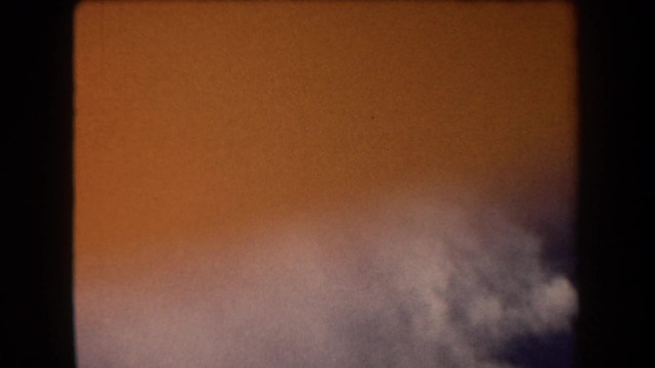Orange sky with gray-white cloud mass entering along the lower right.
