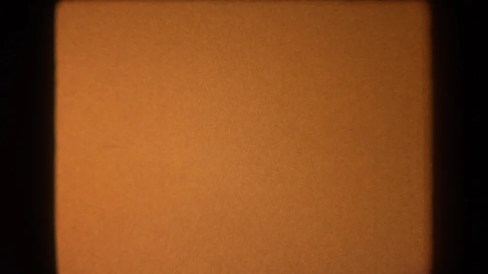 1958 Arizona 8mm frame showing a mostly orange sky, slight tonal boundary, film grain, and dark gate border.