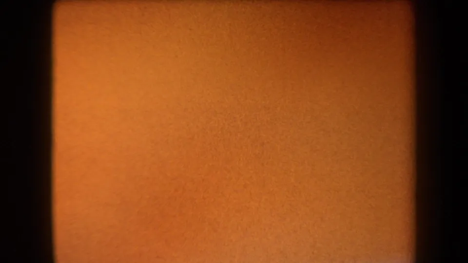 1958 8mm Arizona clip begins on a warm orange leader frame with dark gate edges and no visible landscape yet.