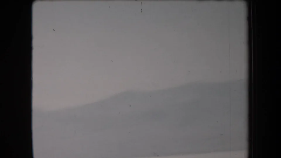 Soft 8mm frame showing the pale salt-flat surface with minimal visible activity and a dark partial shape near the bottom edge.