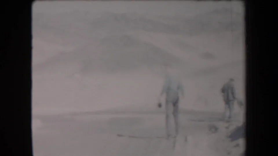 Soft 1958 Arizona 8mm frame with a man standing in the desert and another man partly visible near the right edge.