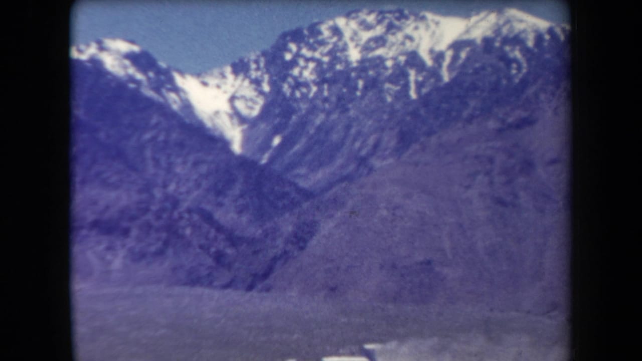 Close view of a rugged mountain range with patches of snow near the peaks.