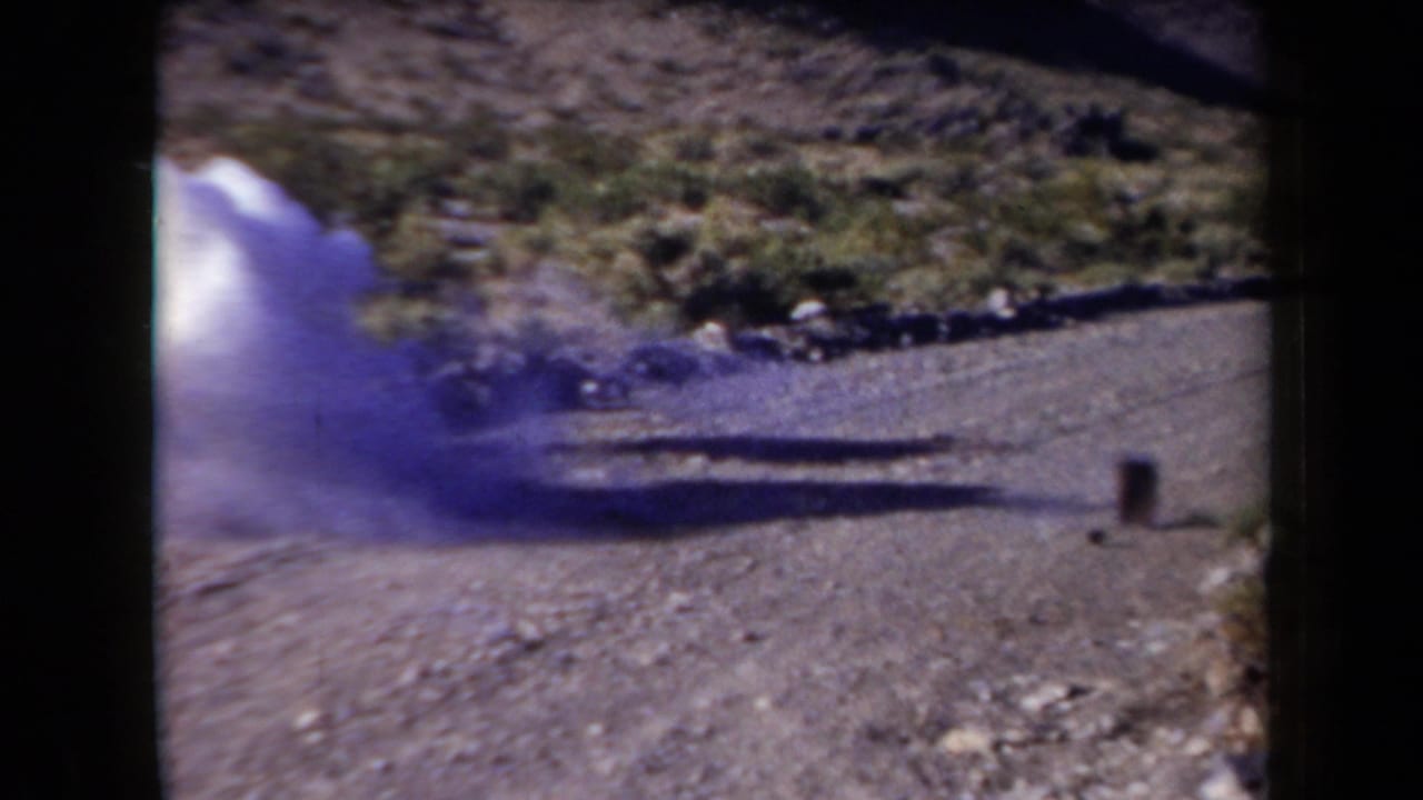 1958 Arizona frame with a smoke burst near the roadside can target during apparent shooting practice.