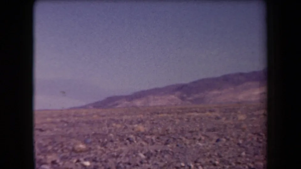 Arizona 8mm travel frame from 1958 showing a rocky arid plain and broad mountain slope.