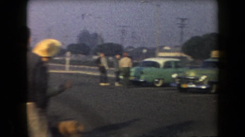 The final 1958 Arizona frame shifts to a street scene with pedestrians near parked mid-century cars, including a green car.