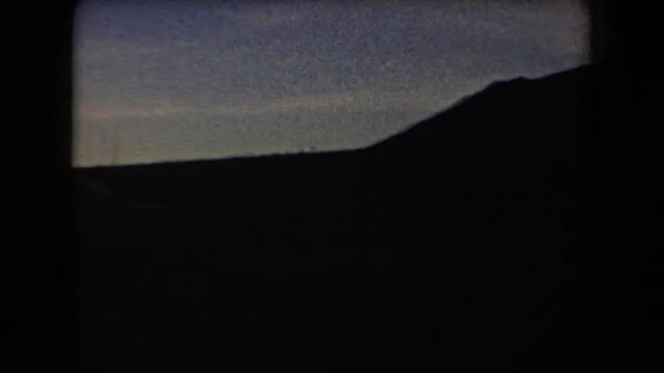 Arizona 1958 view across a dark mountainside and valley beneath a hazy twilight sky.