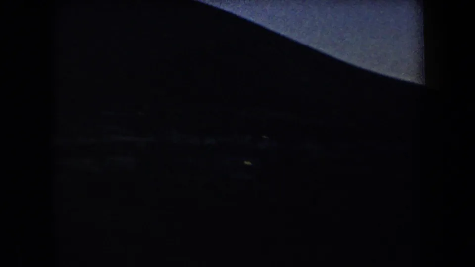 Dark 1958 Arizona mountain view with faint lights below the ridge and a narrow band of twilight sky.