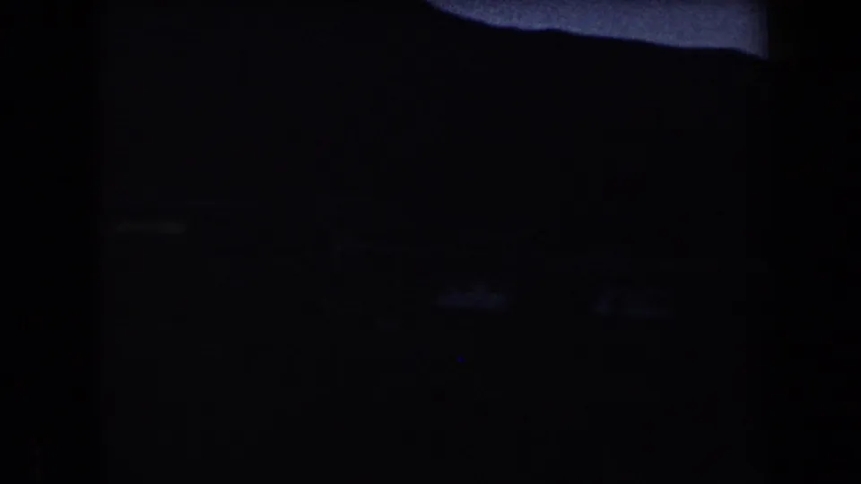 Near-dark Arizona 8mm frame from 1958 showing a mountain silhouette and only a narrow remaining band of dusk light.