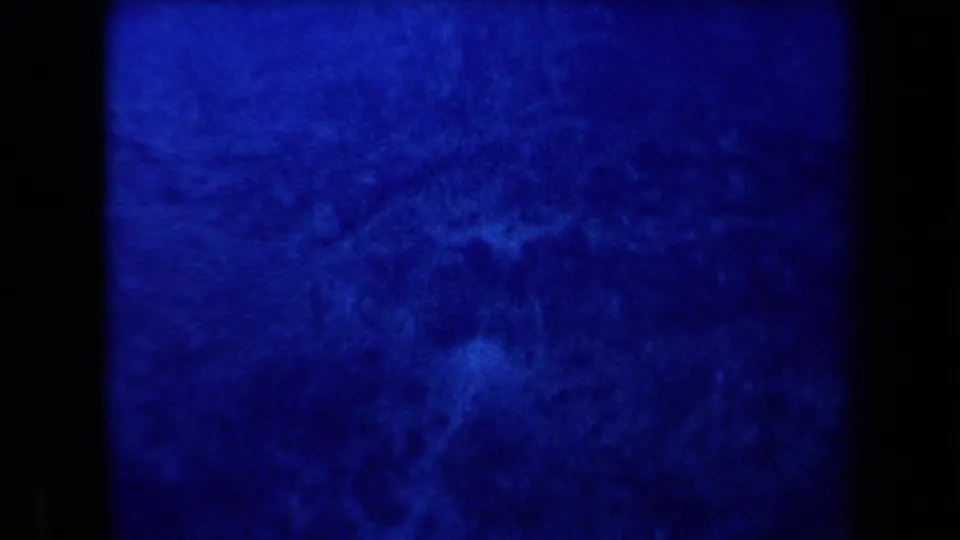 1958 Arizona frame showing a blue-lit mountain or hillside texture, with no people or vehicles visible.