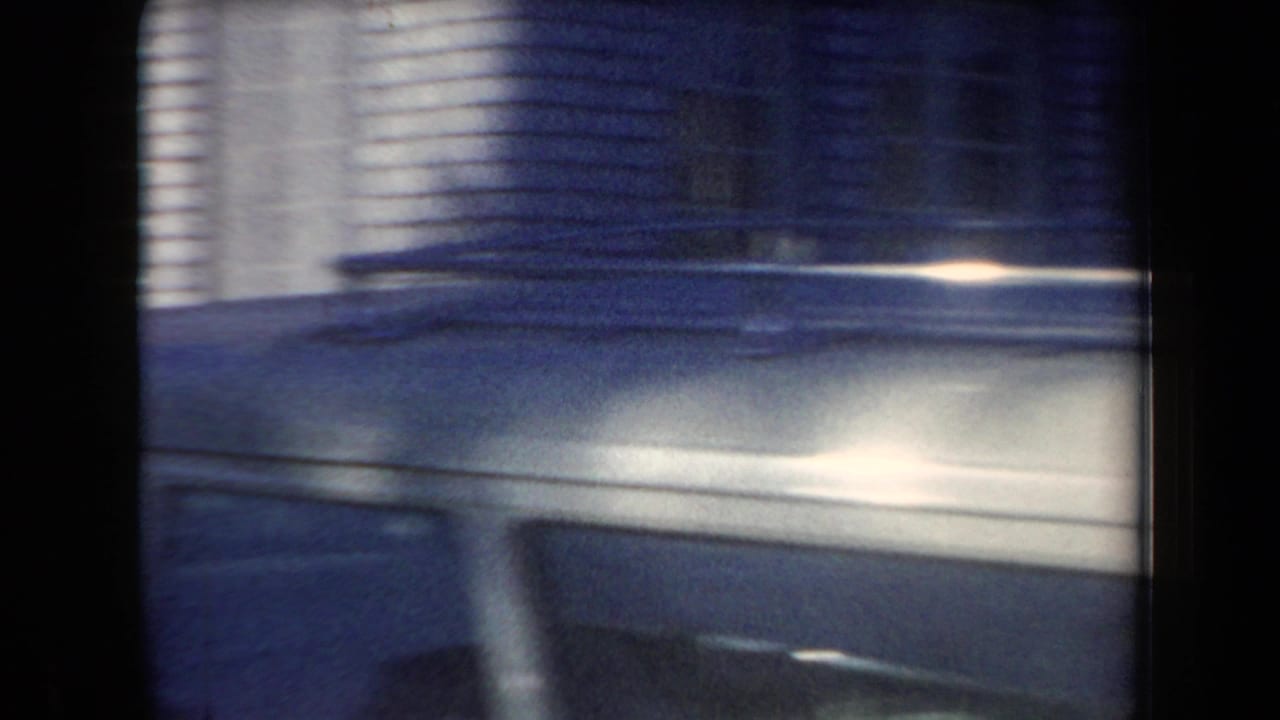 Soft 8mm frame with motion blur across a light-colored vehicle surface, likely at the start of the Arizona roadside clip.