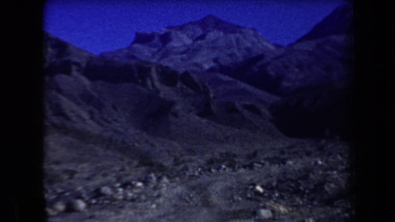 1958 Arizona home-movie view of rugged rocky mountains and arid terrain beneath a saturated blue sky.