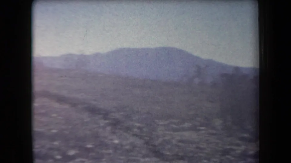 1958 Arizona home-movie view of a distant mountain ridge across rocky open desert terrain.