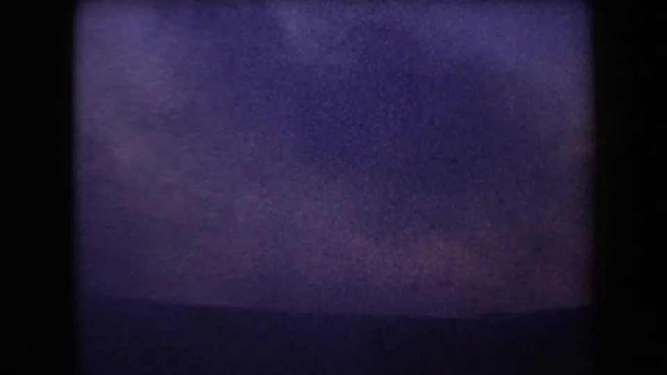 1958 Arizona 8mm view showing a faint desert horizon beneath a pale purple sky and dark frame edges.