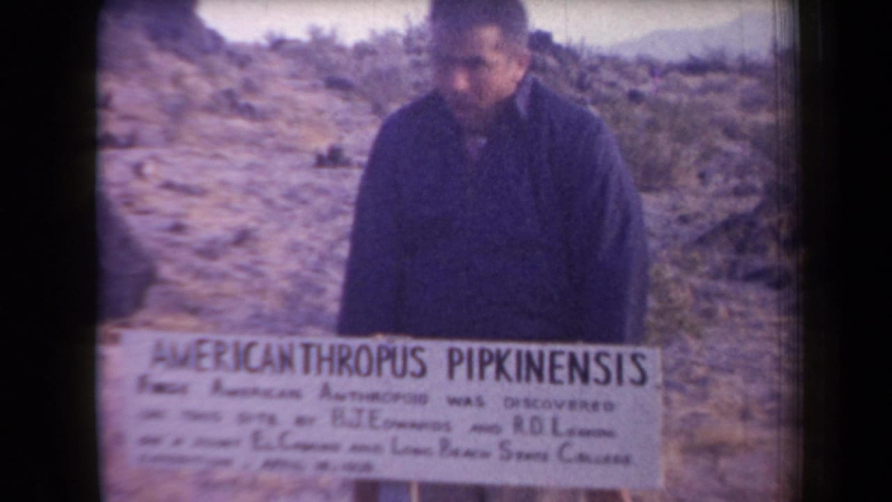 Man looking down near the Americanthropus Pipkinensis sign in a desert landscape.