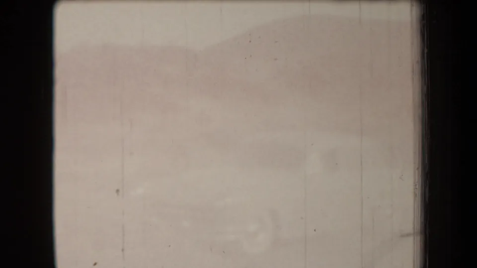 Faded final 8mm frame with faint traces of the desert scene, vertical film marks, and heavy exposure wash.