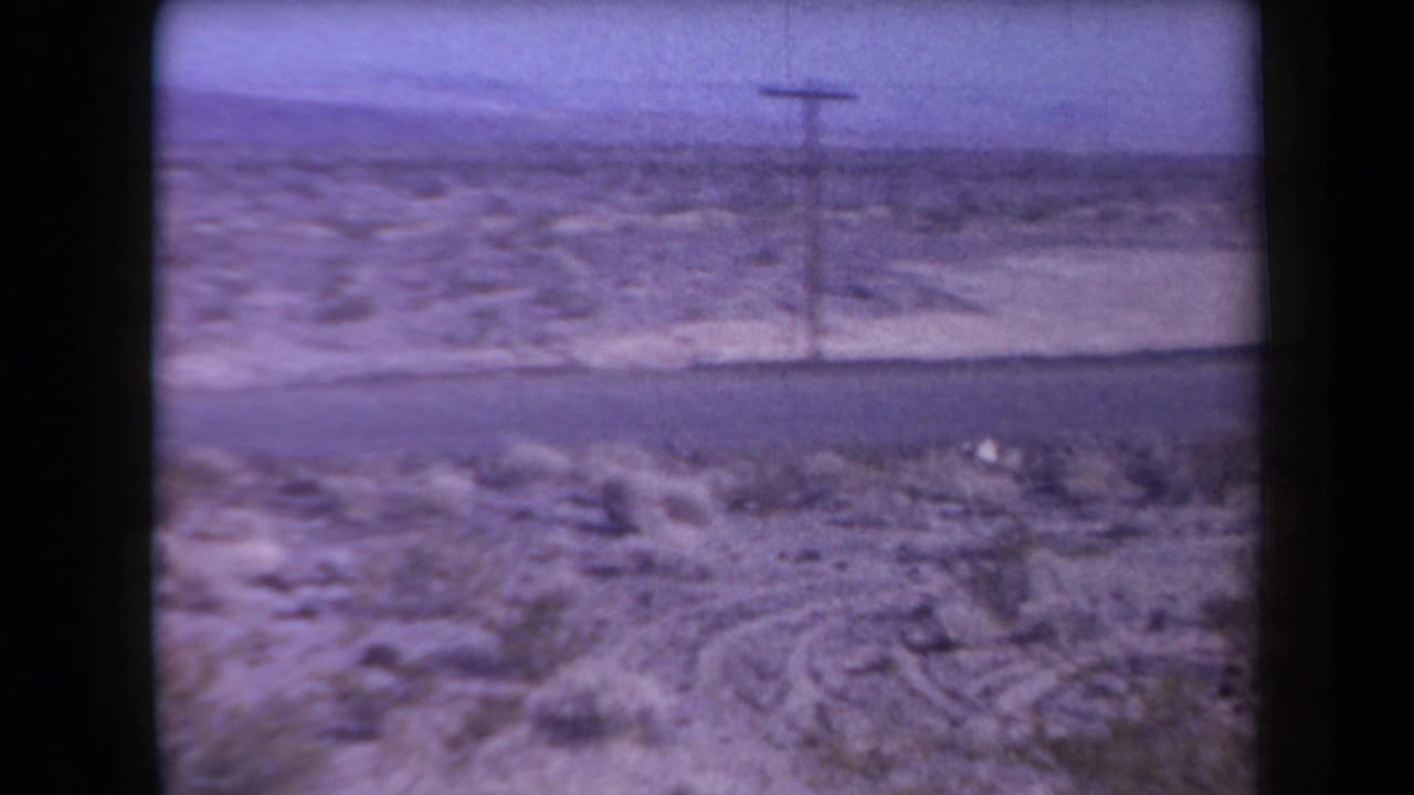 Arizona desert highway scene from 1958 metadata, showing scrubland, a road, a utility pole, and distant low horizon.