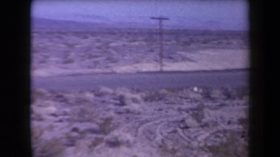 Arizona desert highway scene from 1958 metadata, showing scrubland, a road, a utility pole, and distant low horizon.