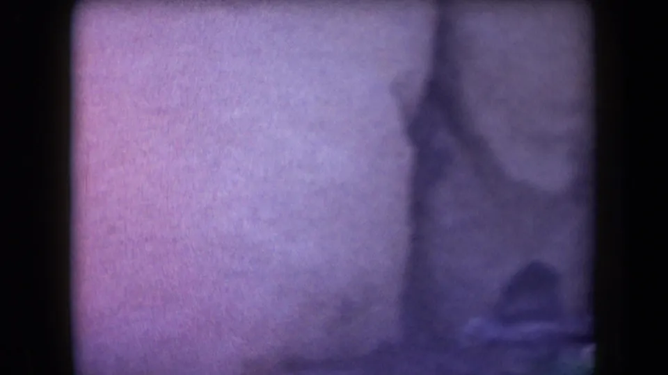 Faded 1958 Arizona 8mm frame with very soft focus, dark border, and barely visible outdoor shapes.