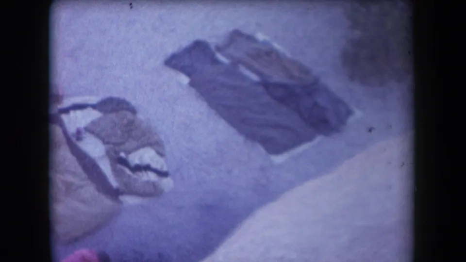 Overhead 8mm frame showing camping gear or sleeping bags on pale ground, likely from the Arizona desert outing.