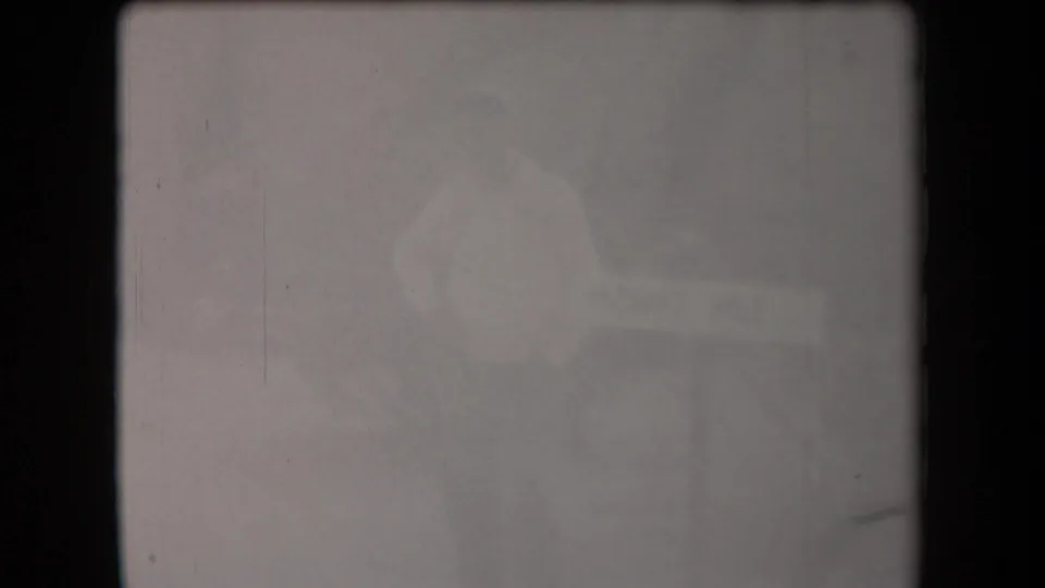 Faded final 8mm frame from the Arizona clip, with overexposed tones and only faint traces of the desert landscape visible.
