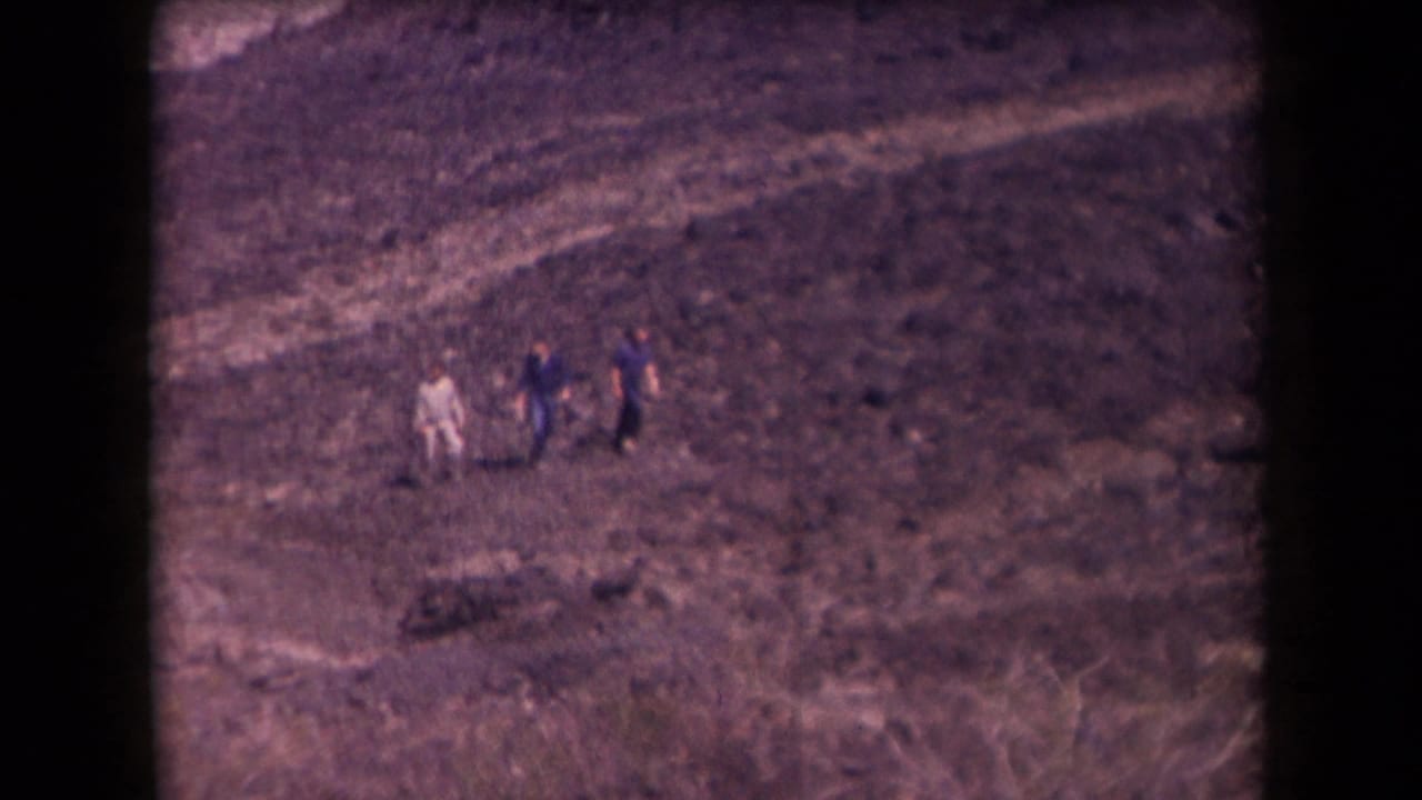 Small group of hikers crossing a rocky, arid hillside.