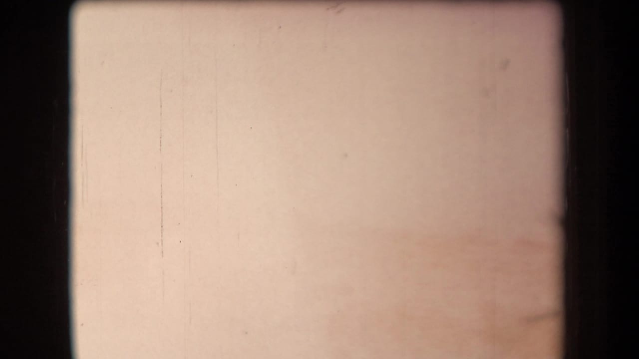 Pale overexposed frame with faint marks and dark 8mm borders.