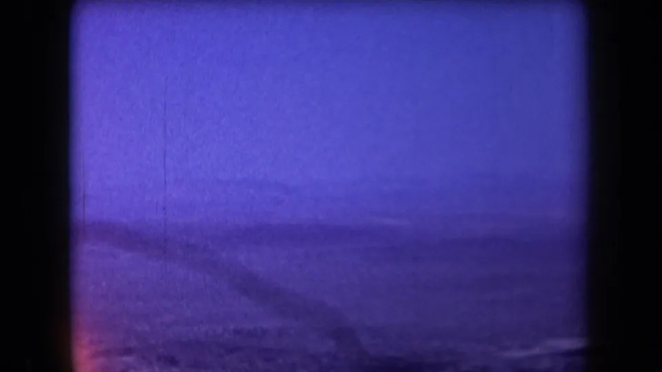 Blue-purple shifted 8mm frame of Arizona desert terrain and distant mountains from an aerial viewpoint.