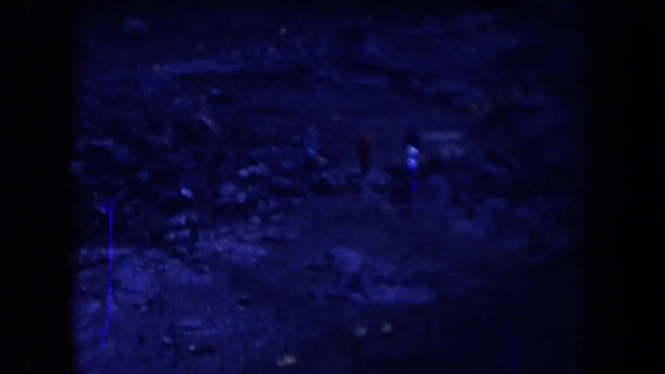 A distant man appears on rugged Arizona desert ground in a blue-tinted 1958 8mm home-movie frame.