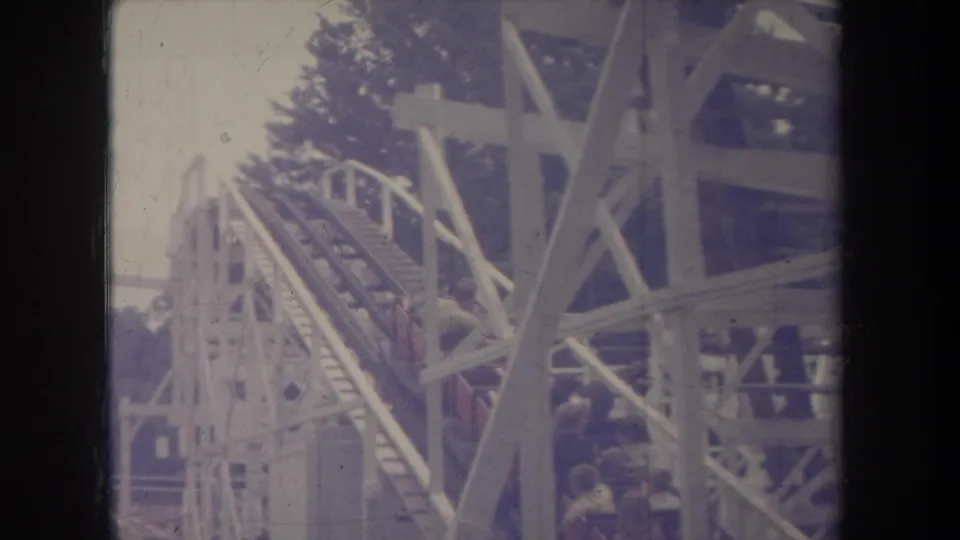 1968 Michigan 8mm frame showing a coaster lift hill with riders partially obscured by white timber supports.