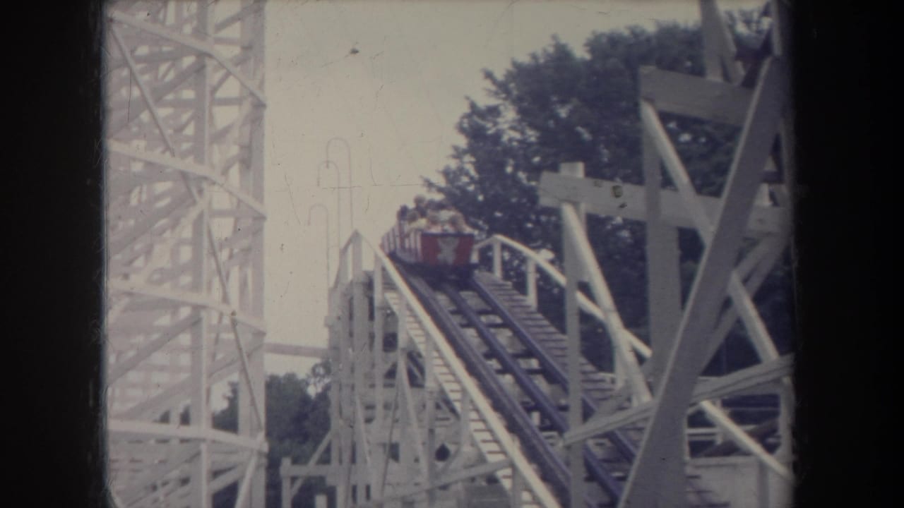 Roller coaster car near the top of a white wooden track.