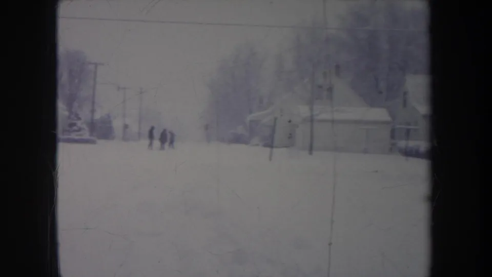 1968 metadata-supported 8mm winter street view in Michigan, showing distant people against a snowy suburban backdrop.