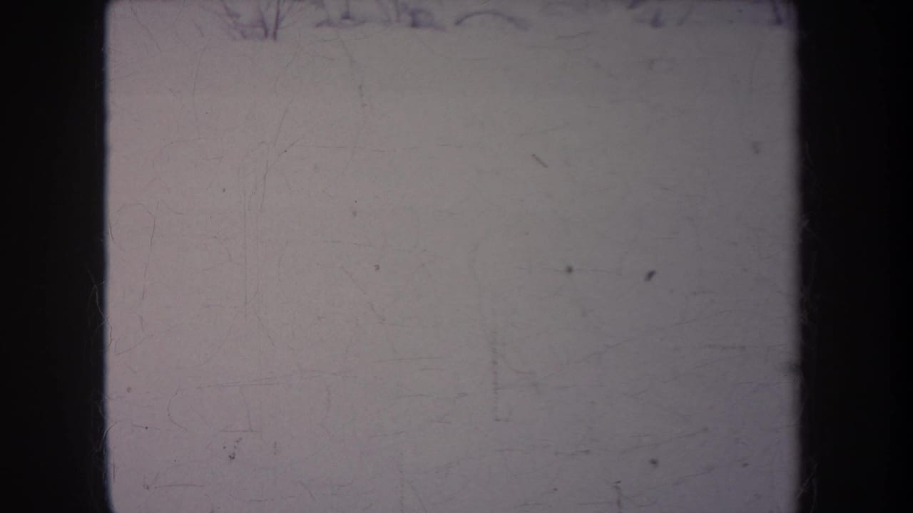 1968 Michigan 8mm frame showing mostly pale leader or overexposed snowy yard with dark gate edges and film scratches.