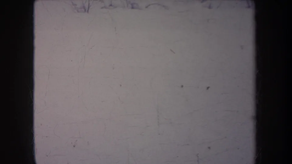 1968 Michigan 8mm frame showing mostly pale leader or overexposed snowy yard with dark gate edges and film scratches.