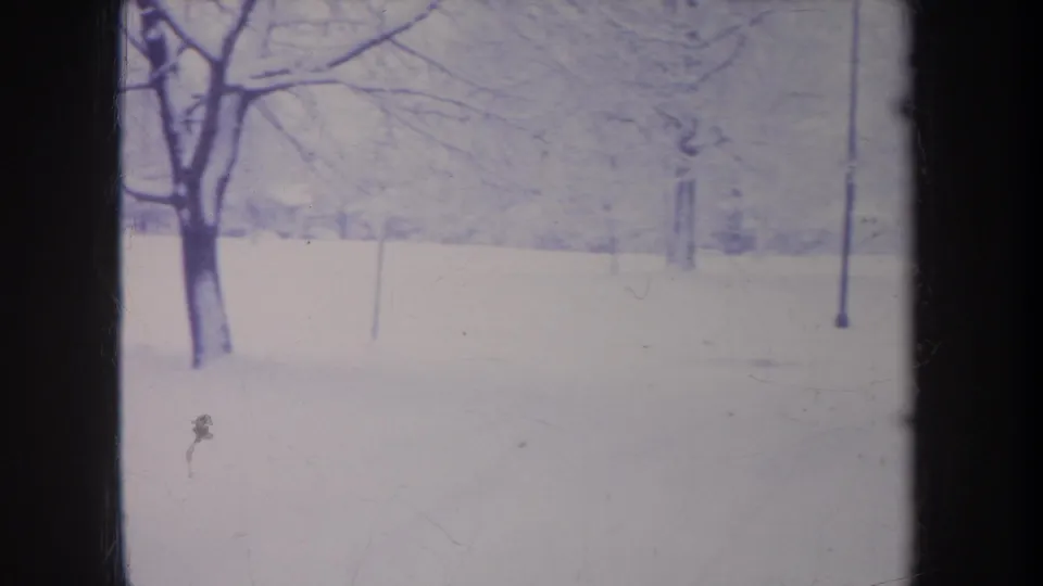 1968 Michigan 8mm frame showing a quiet snow-covered landscape with leafless trees and soft blue-white exposure.