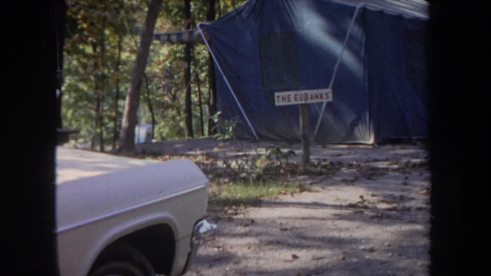 A blue canvas tent marked THE EUBANKS stands among trees at the 1968 Michigan campsite.