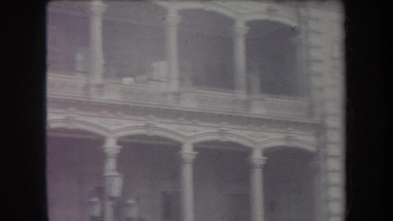 Soft view of arched windows and columns on a stone building facade.