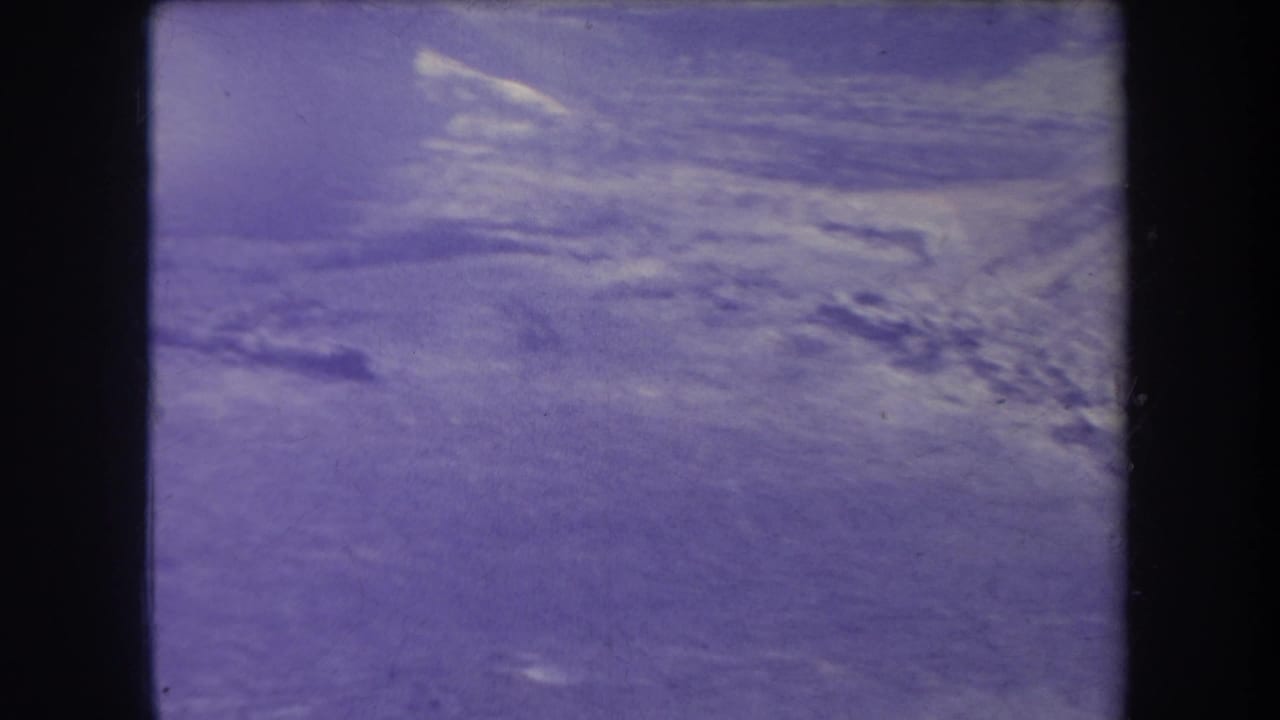 Soft distant ridge and bright haze under a purple-blue aged film tint.