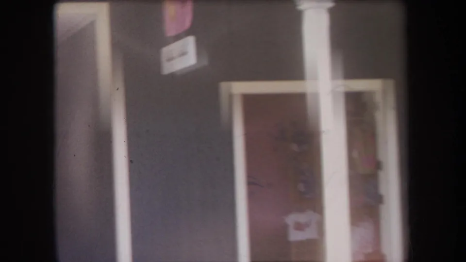 1969 Hawaii storefront detail with a dark facade, white trim, doorway, window, and partially legible posted signs.