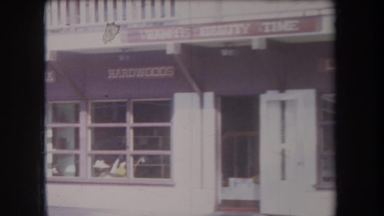 Storefront entrance with awnings, large windows, and readable business signage above.